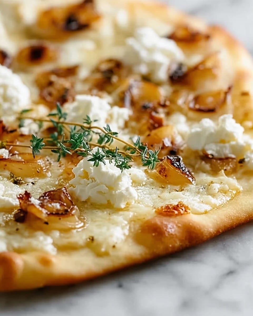 The image shows a close-up of a flatbread with a thin, golden crust as the base layer, slightly crispy and light brown at the edges. On top, there is a melted, creamy white cheese layer that spreads evenly across the flatbread, appearing smooth and glossy. Scattered over this cheese are small browned pieces of roasted garlic or perhaps lightly caramelized chunks, adding texture and dark golden-brown spots. Dollops of fresh, soft white cheese are placed unevenly around, adding contrast and creaminess. A small sprig of fresh thyme with green leaves rests near the center, adding a touch of color and freshness. The flatbread is sitting on a white marbled surface. photo taken with an iphone --ar 4:5 --v 7