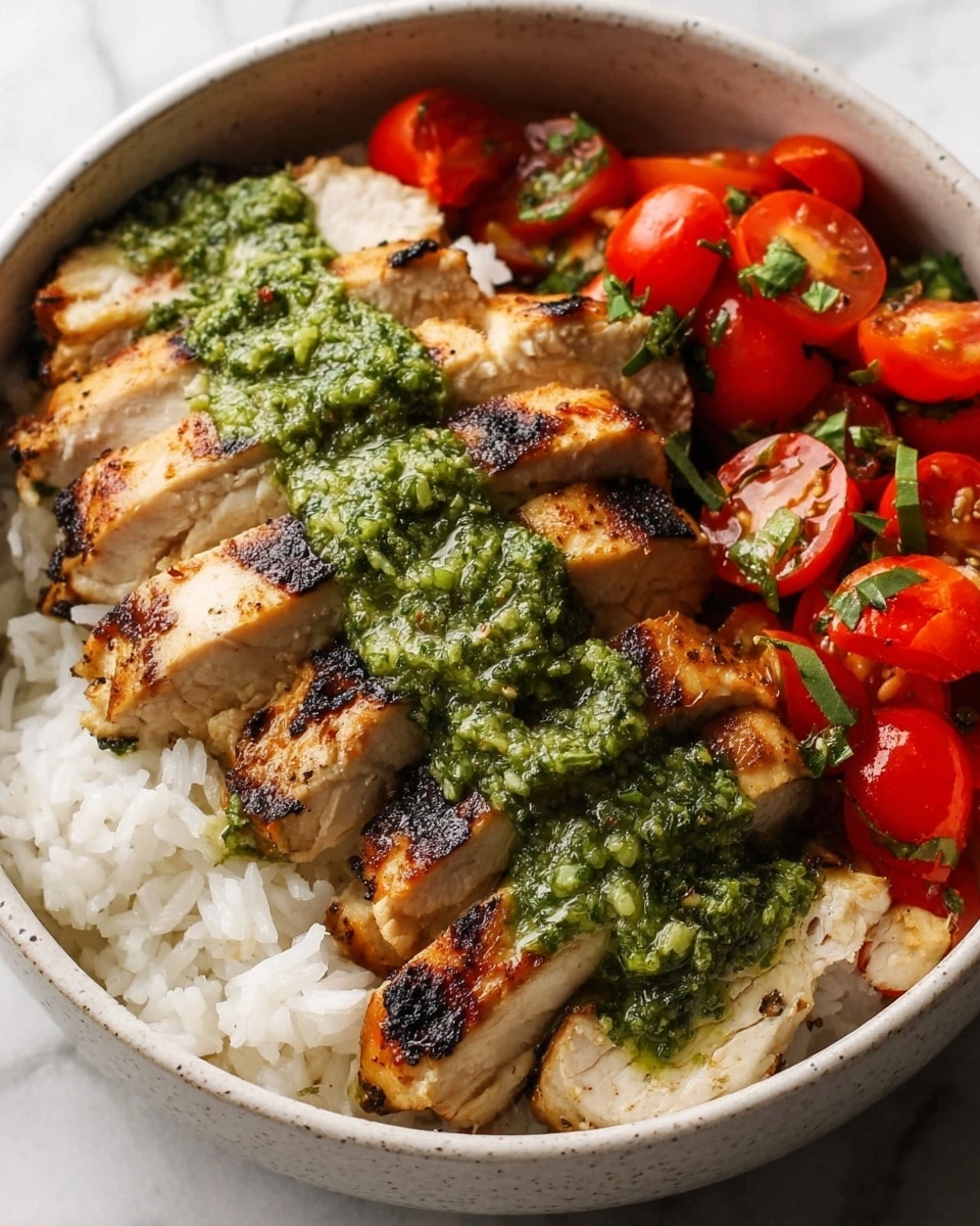 A bowl with three main layers sits on a white marbled texture. The bottom layer is fluffy white rice, spread evenly at the base. On top, there is sliced grilled chicken breast arranged in a neat row on the left side, with clear browned grill marks and specks of green herbs. A bright green, coarse textured sauce runs over the middle of the chicken slices. On the right side, there are halved cherry tomatoes mixed with finely chopped green herbs, creating a fresh and colorful contrast. photo taken with an iphone --ar 4:5 --v 7