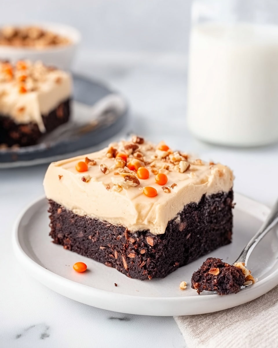 The image shows a square piece of dessert on a white plate with a white marbled surface background. The dessert has two clear layers: the bottom layer is a dark, moist chocolate brownie with a rich texture, while the top layer is a smooth, creamy beige frosting sprinkled with small orange candy drops and chopped nuts. A small piece of the brownie is broken off and placed beside the main piece on the plate. There is a spoon in the background and a glass of milk blurred behind. Photo taken with an iphone --ar 4:5 --v 7