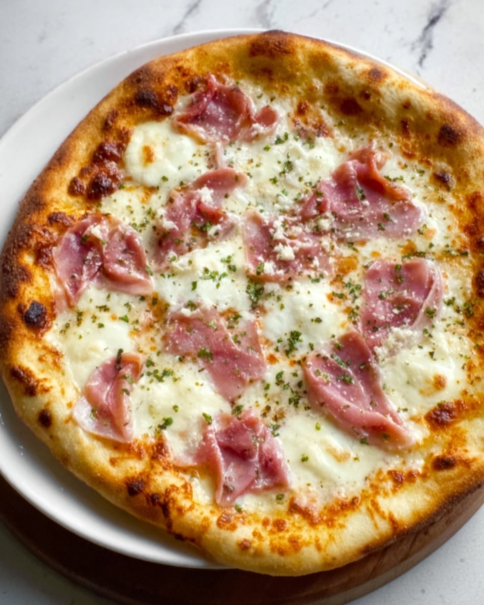 A round pizza with a golden, slightly puffy crust sits on a white marbled surface. The pizza has three main layers visible from top to bottom: a light red tomato sauce spread evenly beneath, dotted with melted white mozzarella cheese that looks stretchy and creamy, and topped with thin slices of pink prosciutto scattered across the surface. Small green herbs are sprinkled lightly on top, adding a contrast to the warm colors. The crust's edges are slightly browned and bubbly, and the overall look is fresh and inviting. Photo taken with an iphone --ar 4:5 --v 7
