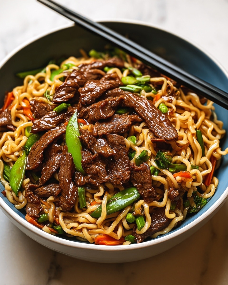 A close-up of a blue bowl filled with three layers: the bottom layer is light yellow cooked noodles with a smooth and slightly shiny texture, tangled loosely; the middle layer features dark brown, glossy strips of beef scattered evenly over the noodles; and the top layer shows small pieces of green and red bell pepper adding pops of color, with a pair of black chopsticks picking up some noodles and beef from the right side of the bowl, all set against a white marbled texture background. photo taken with an iphone --ar 4:5 --v 7
