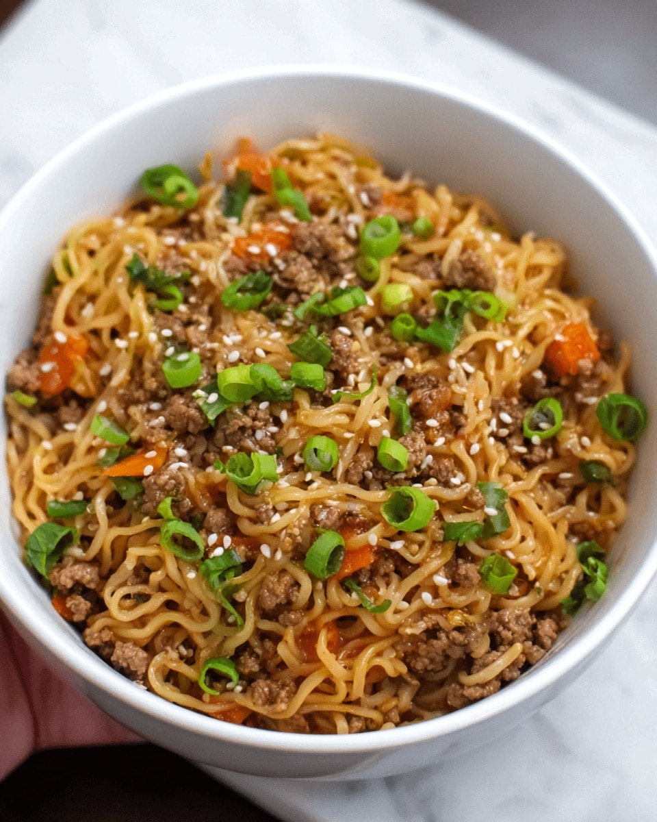 A white bowl filled with a layered dish starting at the bottom with cooked noodles that are light yellow and slightly shiny. On top of the noodles, there are small pieces of browned meat mixed with finely chopped orange carrots and green scallion slices, adding texture and color. The whole dish is sprinkled lightly with white sesame seeds, giving a bit of contrast. The bowl is placed on a white marbled surface. photo taken with an iphone --ar 4:5 --v 7